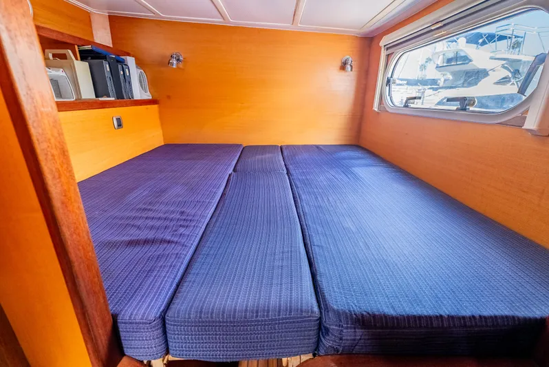 Nina May Yacht Photos Pics Cozy cabin interior of 2001 Catana 431 with blue bedding and wooden walls.