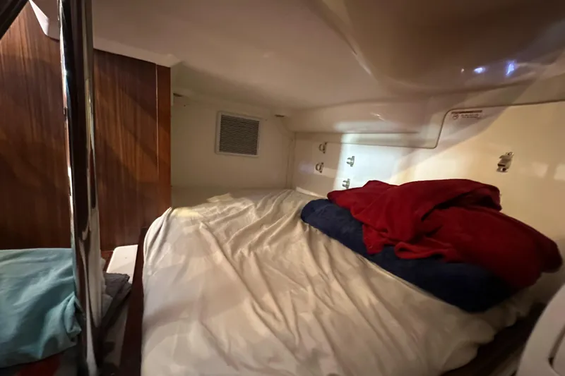  Yacht Photos Pics Cozy cabin interior of 2017 Pursuit OS 355 Offshore boat with bed and pillows.