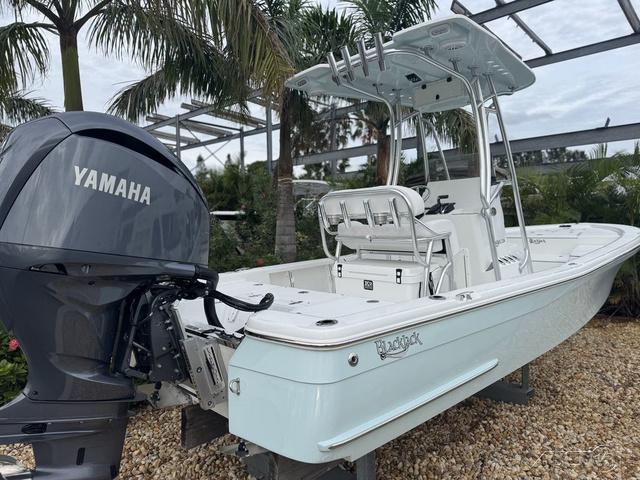 2025 BlackJack 224 boat with Yamaha engine, parked outdoors near palm trees.