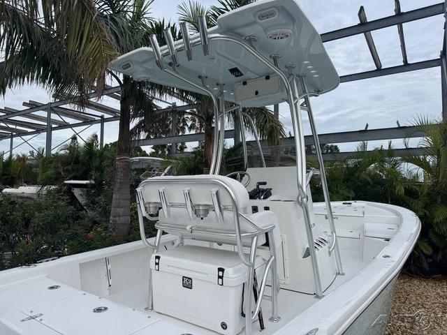 2025 BlackJack 224 boat with T-top and seating, surrounded by tropical plants.