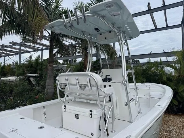 2025 BlackJack 224 boat with T-top and seating, surrounded by tropical plants.