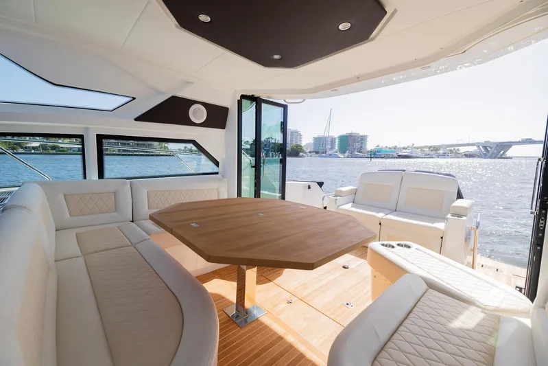 Elixir Yacht Photos Pics Luxurious interior of 2019 Beneteau Gran Turismo 46 yacht with elegant seating and wooden table.
