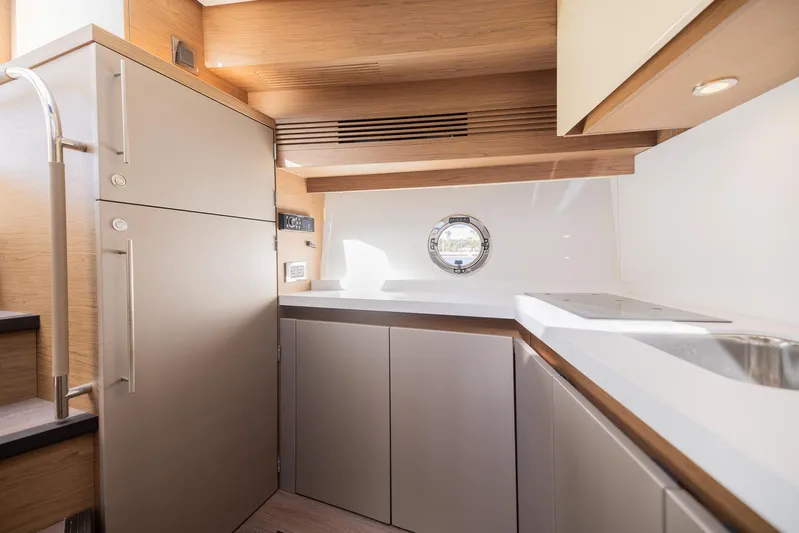 Elixir Yacht Photos Pics 2019 Beneteau Gran Turismo 46 yacht interior kitchen with modern cabinetry and porthole window.