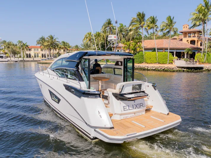 Elixir Yacht Photos Pics 2019 Beneteau Gran Turismo 46 yacht cruising near waterfront homes and palm trees.