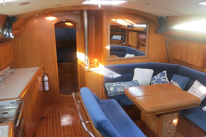 Tangent 2 Yacht Photos Pics Interior of 2002 Jeanneau Sun Odyssey 45.2 yacht with cozy seating and wooden finishes.