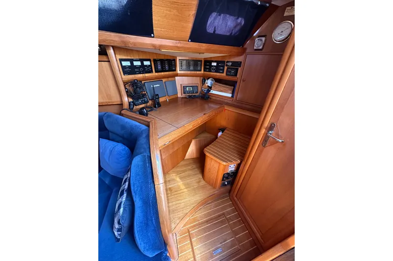 Tangent 2 Yacht Photos Pics Navigation station of 2002 Jeanneau Sun Odyssey 45.2 with wooden interior and control panels.