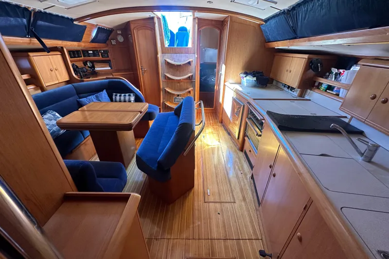Tangent 2 Yacht Photos Pics Interior of 2002 Jeanneau Sun Odyssey 45.2 yacht with wood finish and blue seating.