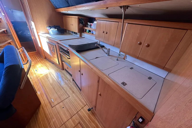 Tangent 2 Yacht Photos Pics Galley kitchen in 2002 Jeanneau Sun Odyssey 45.2 sailboat with wooden cabinetry.