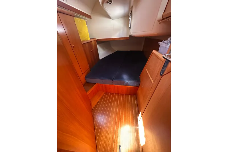 Tangent 2 Yacht Photos Pics 2002 Jeanneau Sun Odyssey 45.2 cabin interior with wooden finish and cozy bedding.