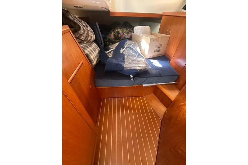 Tangent 2 Yacht Photos Pics Interior cabin of 2002 Jeanneau Sun Odyssey 45.2 with wooden finish and storage items.