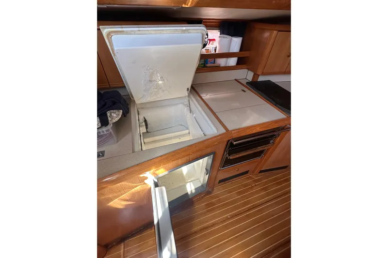 Tangent 2 Yacht Photos Pics Galley of 2002 Jeanneau Sun Odyssey 45.2 with open fridge and wooden cabinetry.