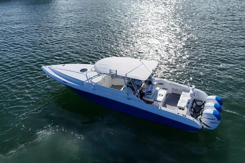  Yacht Photos Pics 2007 Fountain 38 Tournament Edition boat on shimmering water, featuring triple Mercury engines.