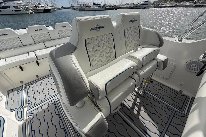  Yacht Photos Pics 2007 Fountain 38 Tournament Edition boat interior with cushioned seating and marina view.