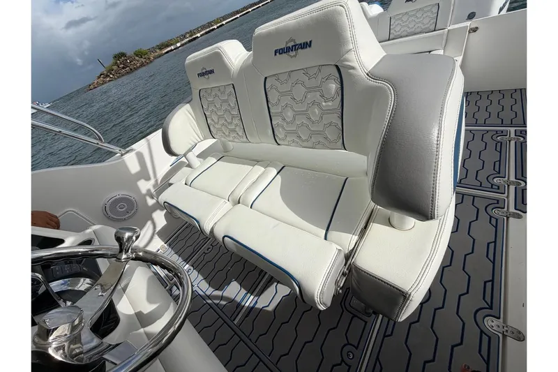  Yacht Photos Pics 2007 Fountain 38 Tournament Edition boat interior with white cushioned seating and steering wheel.