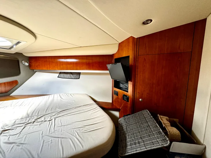  Yacht Photos Pics Interior of 2008 Cruisers Yachts 390 Sports Coupe with bed, TV, and wooden cabinetry.