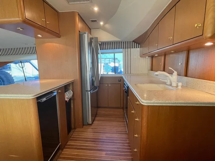 End Game Yacht Photos Pics Luxurious kitchen interior of 2001 Ocean Yachts 56 Super Sport with wood cabinetry and modern appliances.