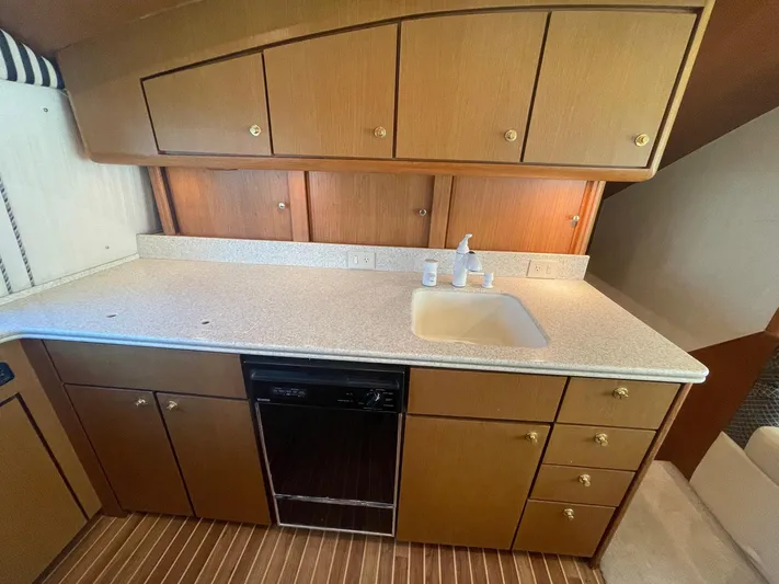 End Game Yacht Photos Pics 2001 Ocean Yachts 56 Super Sport kitchen with wooden cabinets and countertop sink.
