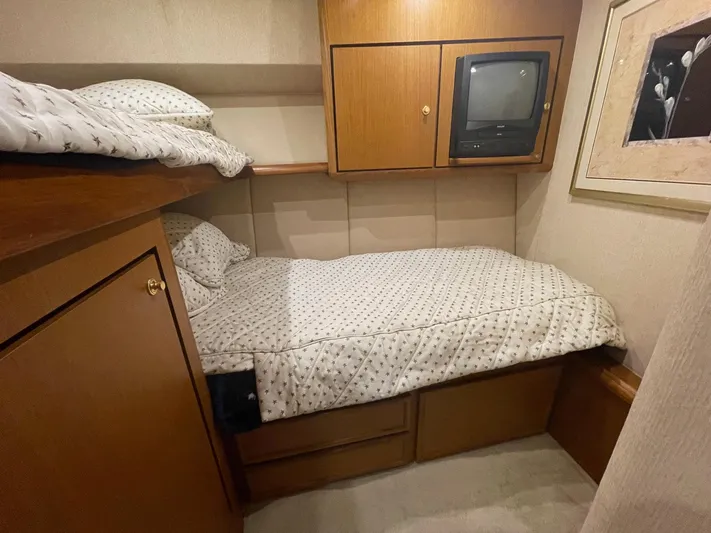 End Game Yacht Photos Pics 2001 Ocean Yachts 56 Super Sport cabin with cozy bed and wooden cabinetry.