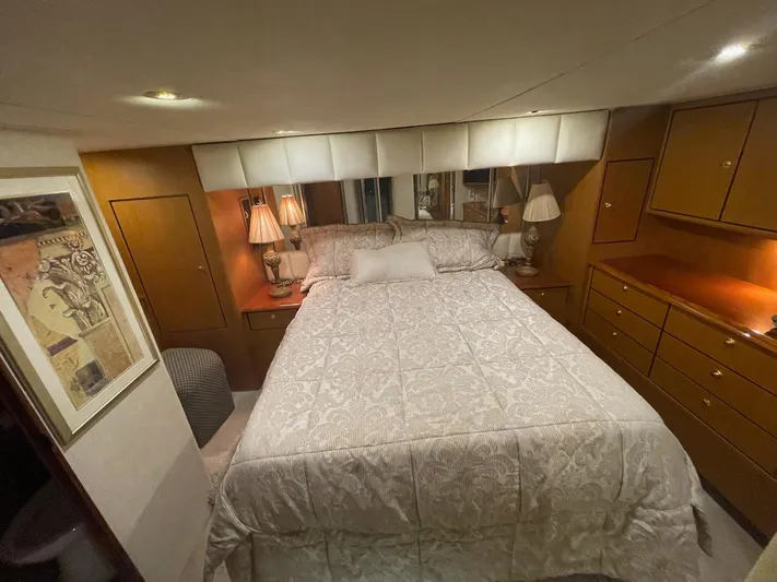End Game Yacht Photos Pics Luxurious bedroom interior of 2001 Ocean Yachts 56 Super Sport with elegant bedding and warm lighting.
