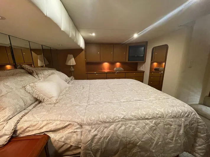 End Game Yacht Photos Pics Luxurious bedroom interior of 2001 Ocean Yachts 56 Super Sport with cozy bedding and elegant decor.