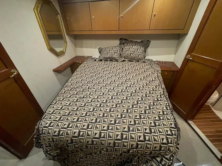 End Game Yacht Photos Pics Bedroom interior of 2001 Ocean Yachts 56 Super Sport with geometric bedding and wooden cabinets.