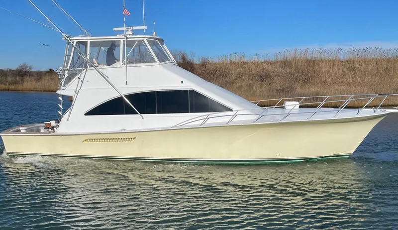 End Game Yacht Photos Pics 2001 Ocean Yachts 56 Super Sport cruising on a calm river under clear blue skies.