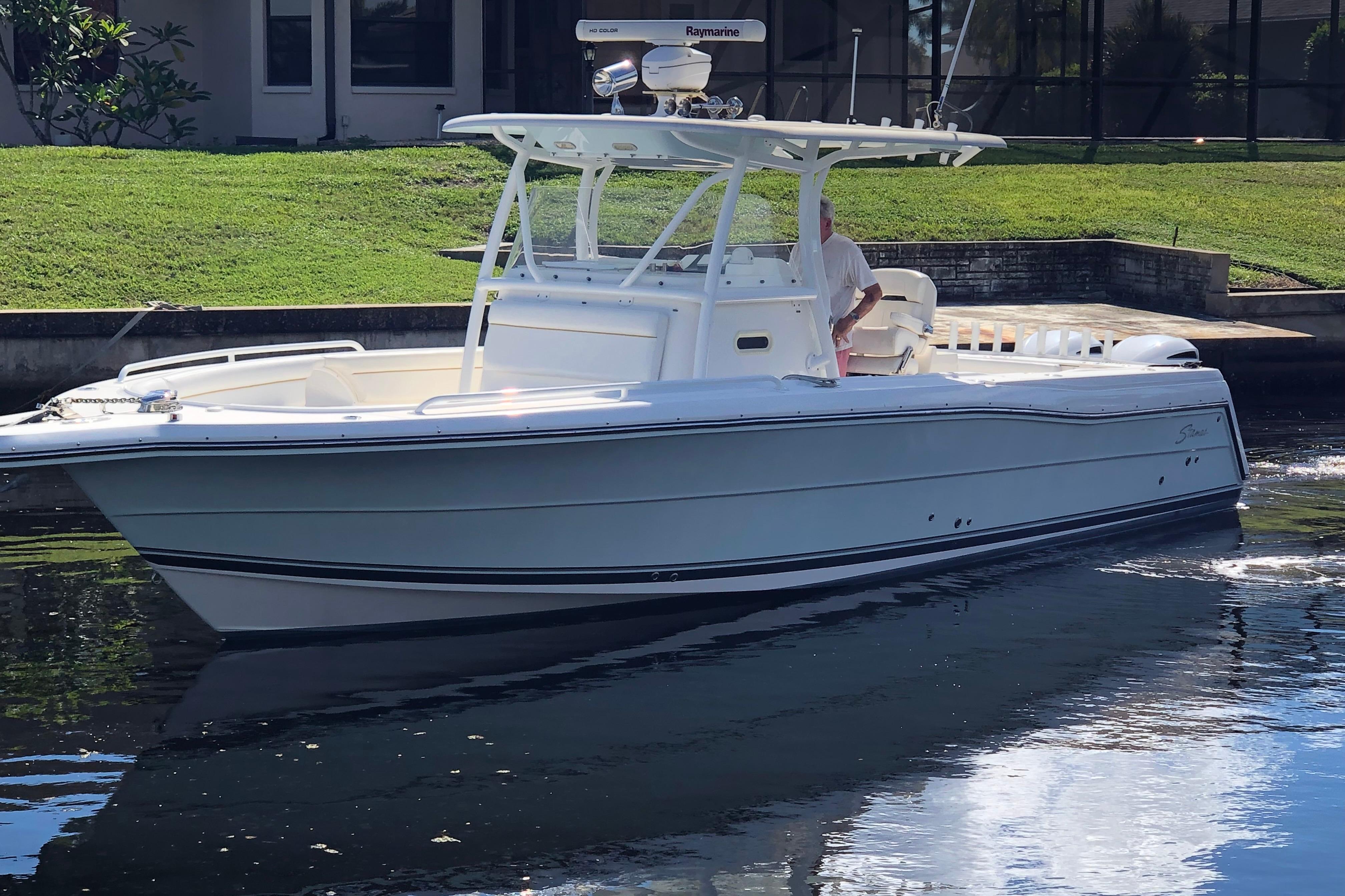 2016 Tarpon 326 boat cruising on a calm waterway near a grassy shoreline.
