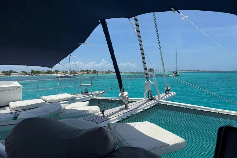 Pelicano Yacht Photos Pics Luxurious Sunreef 62 catamaran, 2009 model, sailing in turquoise waters under a clear sky.