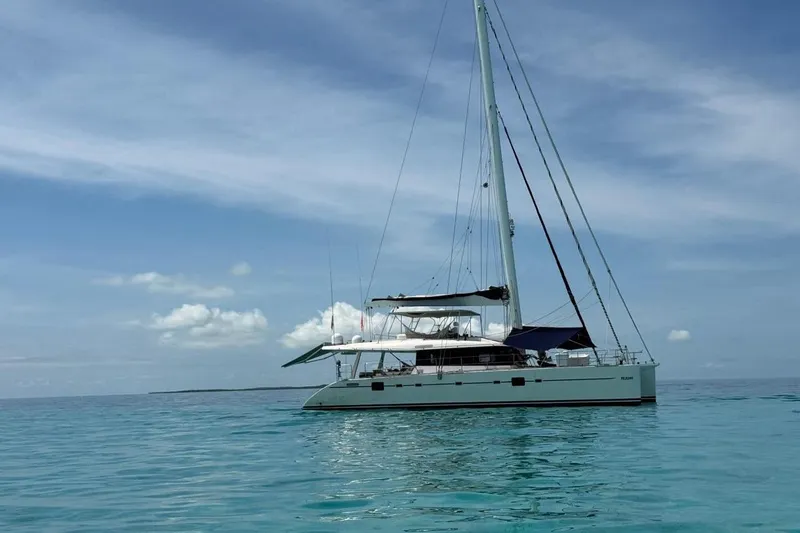 Pelicano Yacht Photos Pics 2009 Sunreef 62 catamaran sailing on calm turquoise waters under a clear sky.