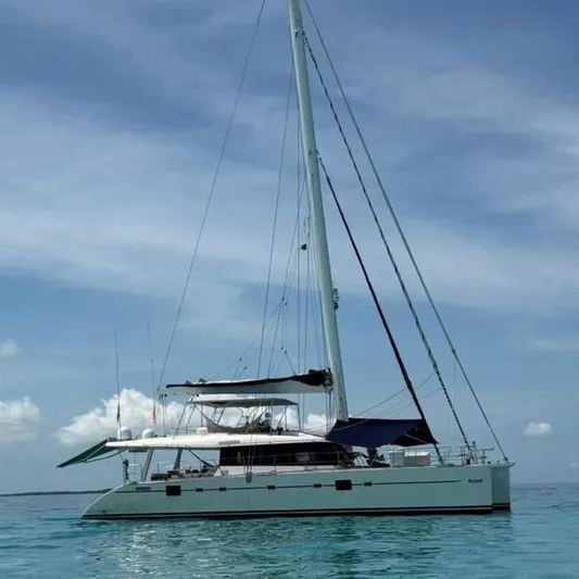 Pelicano Yacht Photos Pics 2009 Sunreef 62 catamaran anchored on calm turquoise waters under a clear sky.