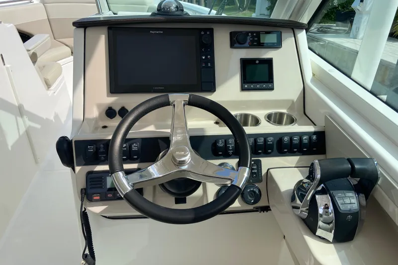  Yacht Photos Pics 2021 Boston Whaler 280 Vantage helm with steering wheel, controls, and navigation display.
