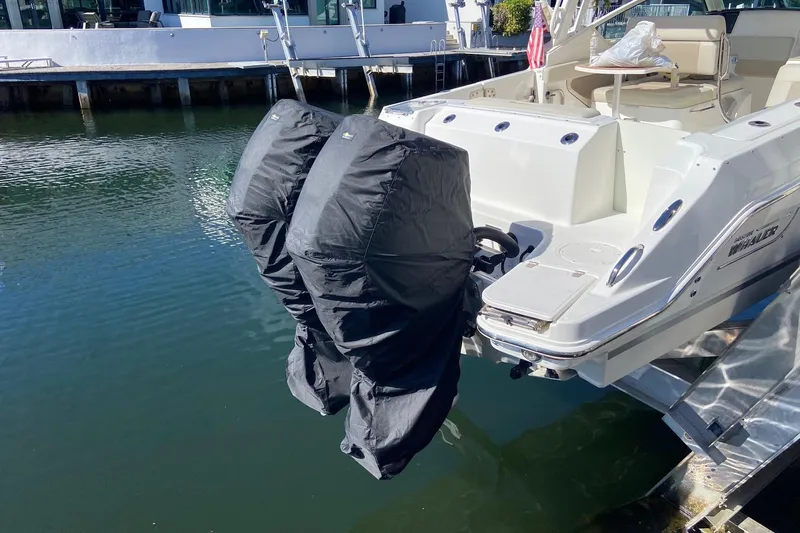  Yacht Photos Pics 2021 Boston Whaler 280 Vantage with covered outboard motors docked by the water.