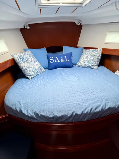 Vita Amoris Yacht Photos Pics Cozy cabin interior of 2005 Beneteau 423 sailboat with blue bedding and decorative pillows.