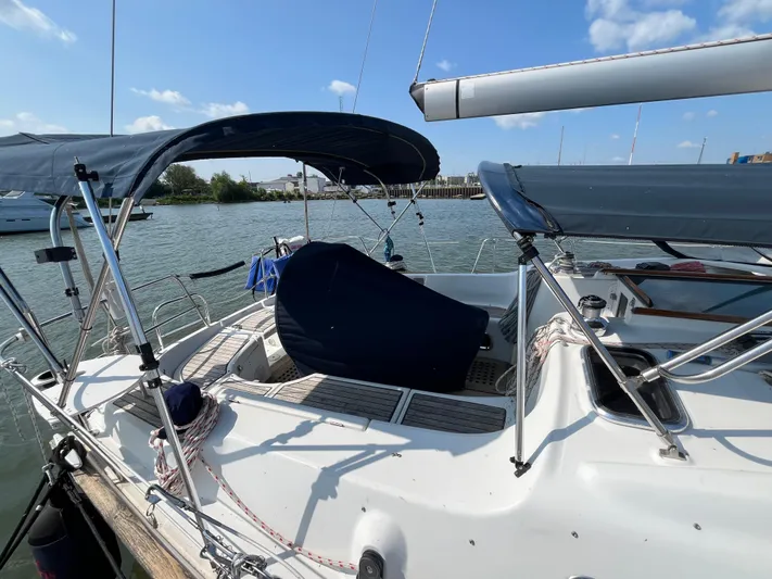 Vita Amoris Yacht Photos Pics 2005 Beneteau 423 sailboat docked, featuring covered cockpit and clear blue sky.