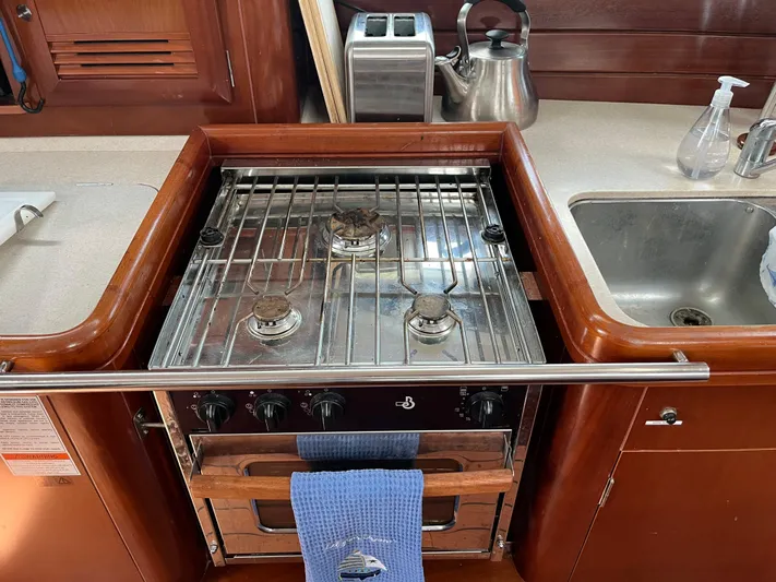 Vita Amoris Yacht Photos Pics Galley kitchen in 2005 Beneteau 423 yacht with stove, sink, and kettle.