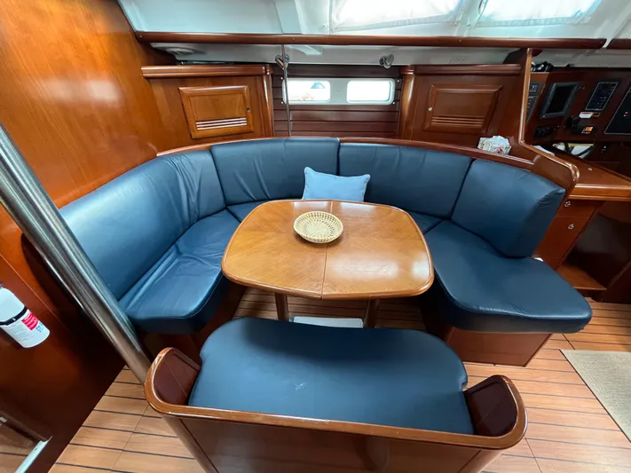 Vita Amoris Yacht Photos Pics Luxurious interior of 2005 Beneteau 423 yacht with blue seating and wooden table.