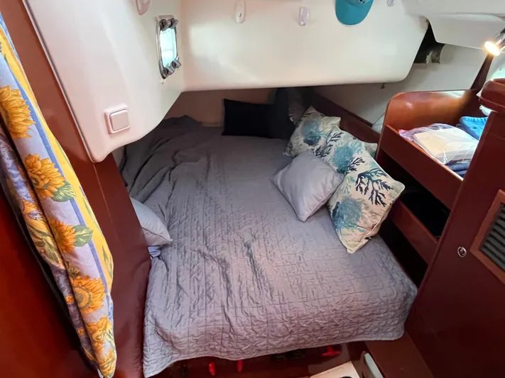 Vita Amoris Yacht Photos Pics Cozy cabin interior of 2005 Beneteau 423 sailboat with bed and decorative pillows.