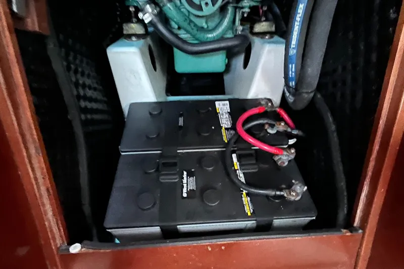 Vita Amoris Yacht Photos Pics Battery compartment of a 2005 Beneteau 423 sailboat, showing connected cables and engine components.