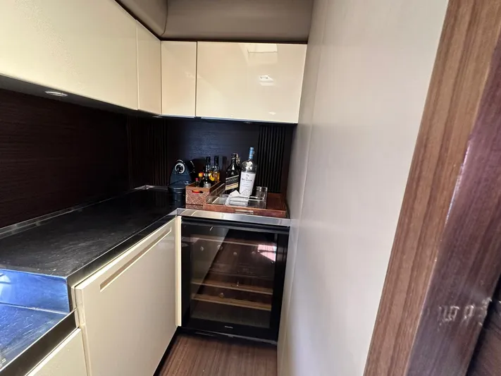 B-enjoy III Yacht Photos Pics Modern kitchenette on a 2012 Azimut 72S yacht with a mini bar and wine cooler.