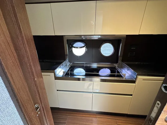 B-enjoy III Yacht Photos Pics Modern kitchen in 2012 Azimut 72S yacht with sleek cabinetry and porthole windows.