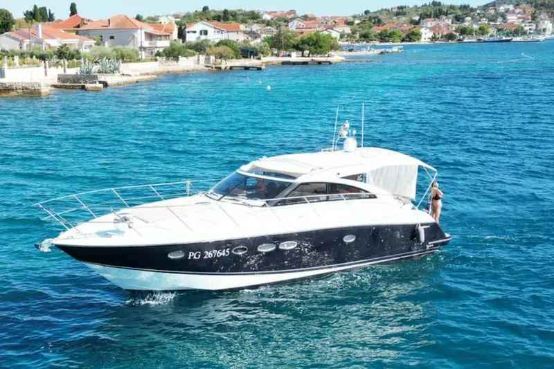  Yacht Photos Pics Luxury 2016 Princess V45 yacht cruising in clear blue waters near a coastal town.