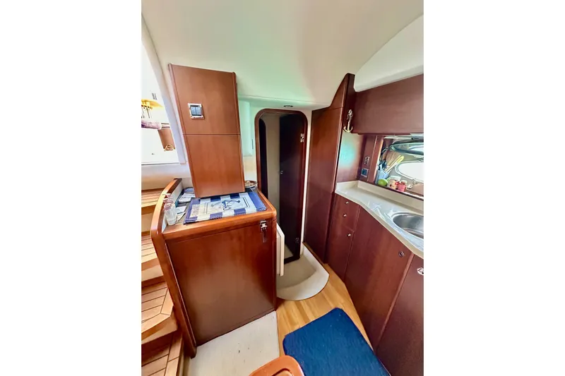  Yacht Photos Pics Interior of 2016 Princess V45 yacht with wooden cabinetry and compact kitchen area.