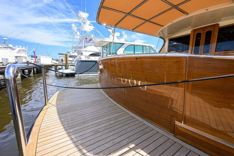 Nauti Dog Yacht Photos Pics 2023 Palm Beach Motor Yachts PB55 docked, showcasing elegant wooden deck and sleek design.