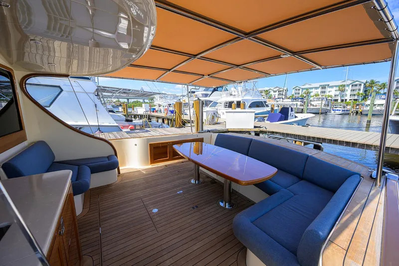 Nauti Dog Yacht Photos Pics Luxurious 2023 Palm Beach Motor Yachts PB55 with spacious deck and elegant seating area.