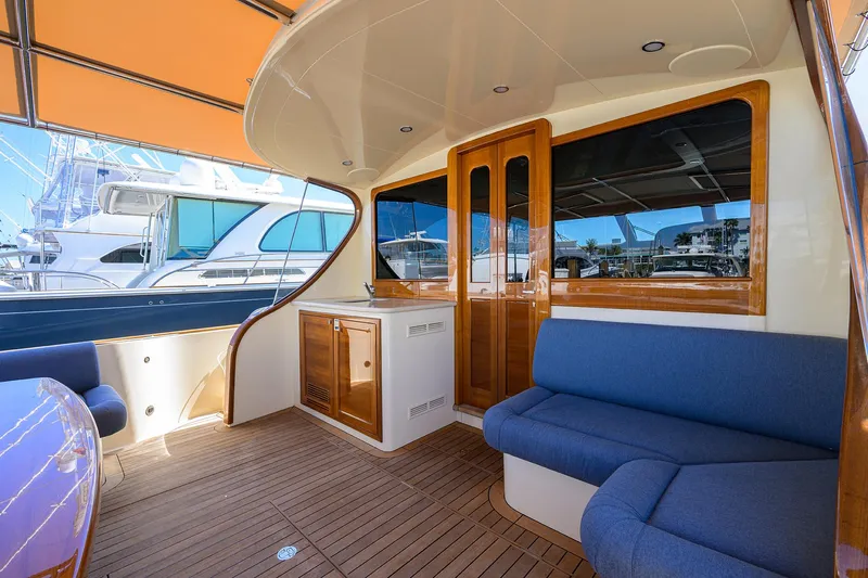 Nauti Dog Yacht Photos Pics 2023 Palm Beach Motor Yachts PB55 interior with blue seating and wooden finishes.