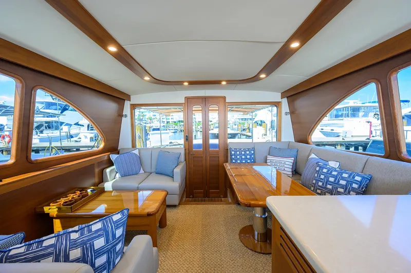 Nauti Dog Yacht Photos Pics Luxurious interior of 2023 Palm Beach Motor Yachts PB55 with elegant wood finishes and plush seating.