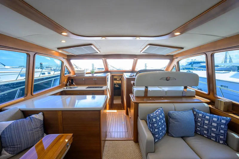Nauti Dog Yacht Photos Pics Luxurious interior of 2023 Palm Beach Motor Yachts PB55, featuring elegant wood finishes and plush seating.