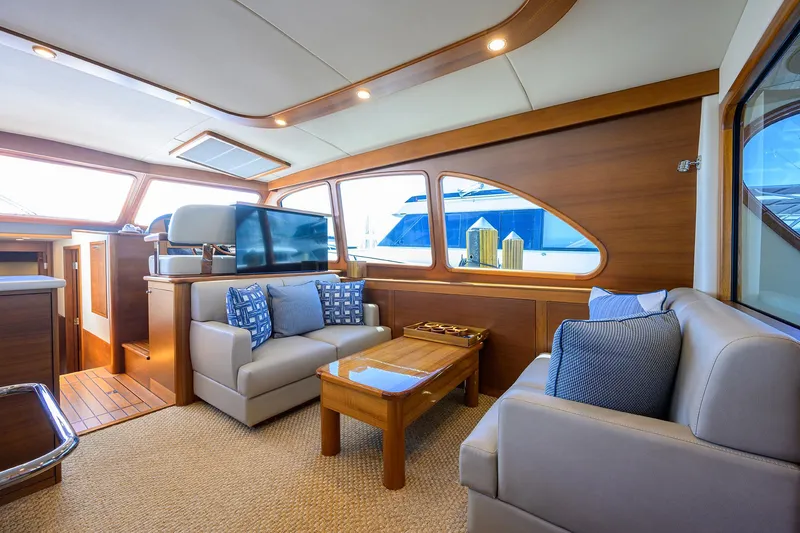 Nauti Dog Yacht Photos Pics Luxurious interior of 2023 Palm Beach Motor Yachts PB55 with elegant seating and wood accents.
