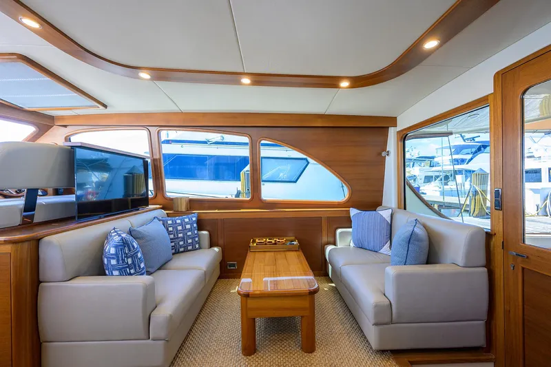 Nauti Dog Yacht Photos Pics Luxurious interior of 2023 Palm Beach Motor Yachts PB55 with elegant seating and wooden accents.
