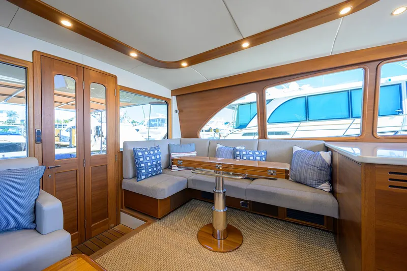 Nauti Dog Yacht Photos Pics Luxurious interior of 2023 Palm Beach Motor Yachts PB55 with elegant wood finishes and plush seating.